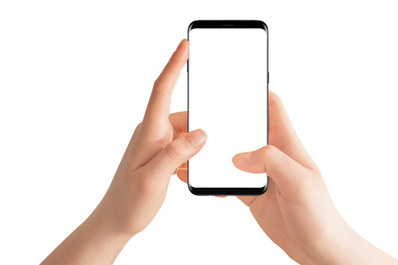 女性双手垂直握着现代的黑色手机白色背景的独立手和智能手机
