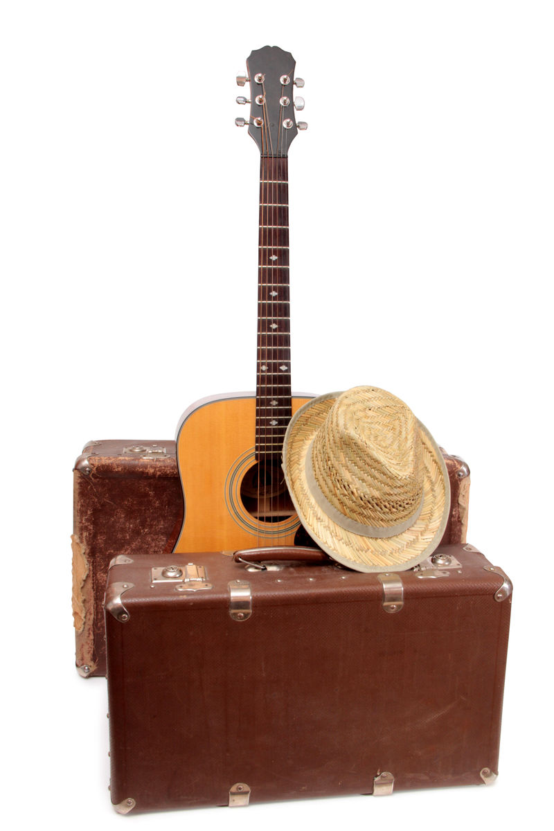 白色背景下的乡村风格的旧手提箱和吉他