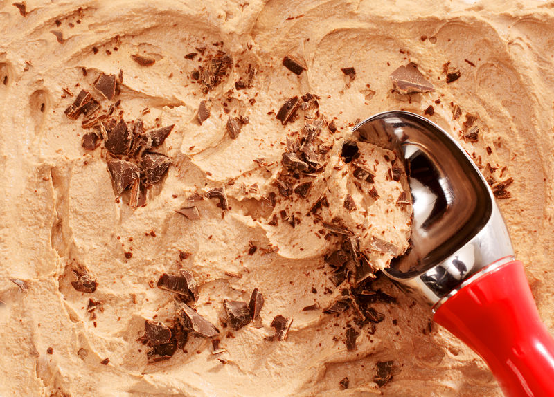 高角度特写镜头红色柄勺供应摩卡或咖啡味冰淇淋上面有巧克力屑