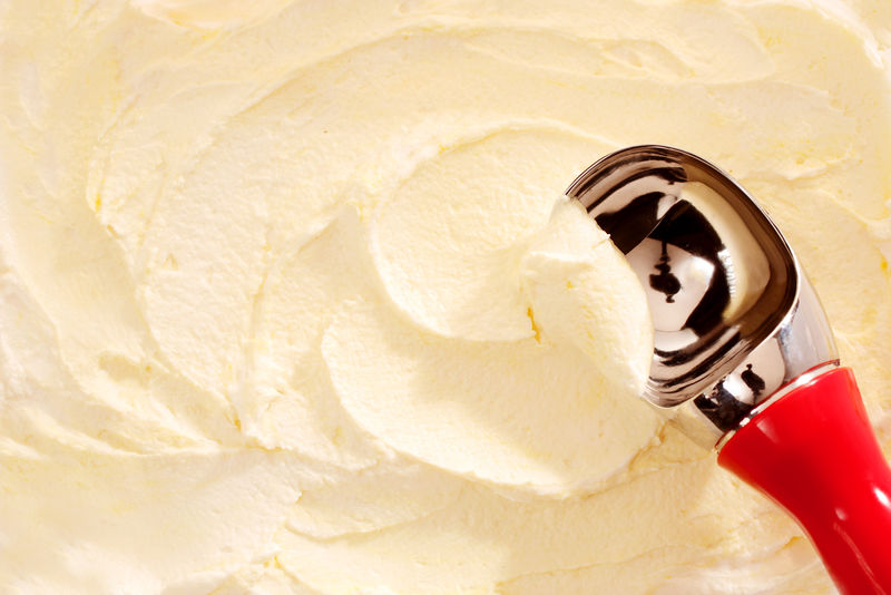提供香草奶油色冰淇淋的红色柄勺的大角度特写视图
