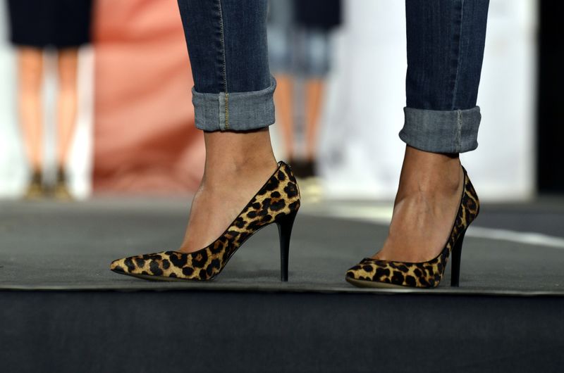 模特配一双时尚豹女高跟鞋-猫步背景上的豹纹高跟鞋特写镜头