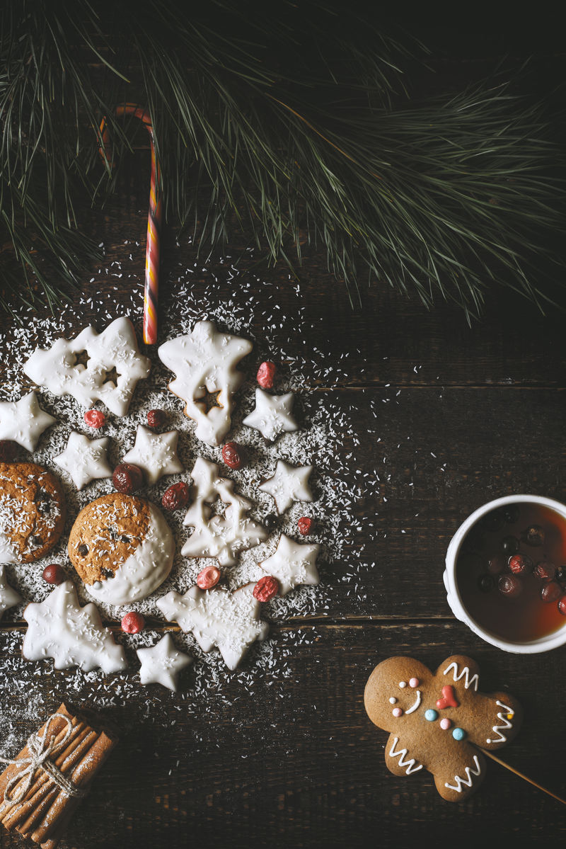 木制背景的曲奇制作的圣诞球茶和姜饼人