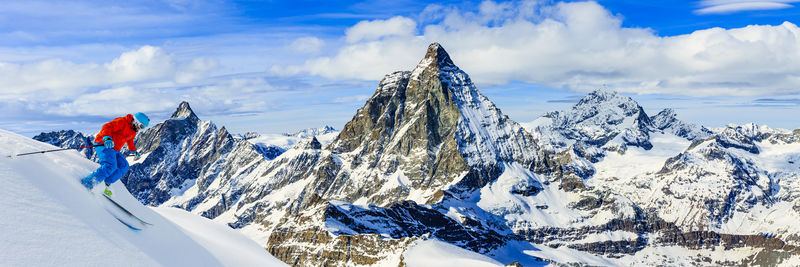在瑞士阿尔卑斯山上男子在以马特霍恩为背景的新鲜粉末雪上滑雪
