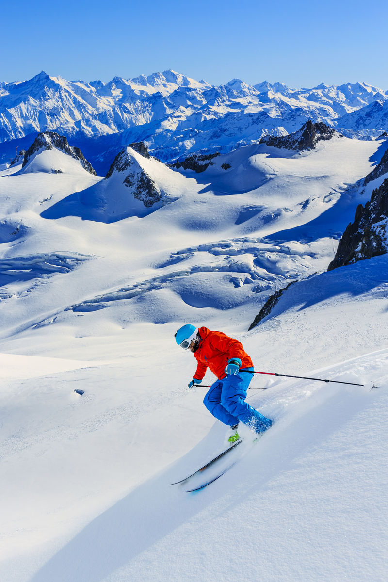 在法国阿尔卑斯高山阳光明媚的冬日一名男子在雪坡上的新鲜雪中滑雪粉雪中的基