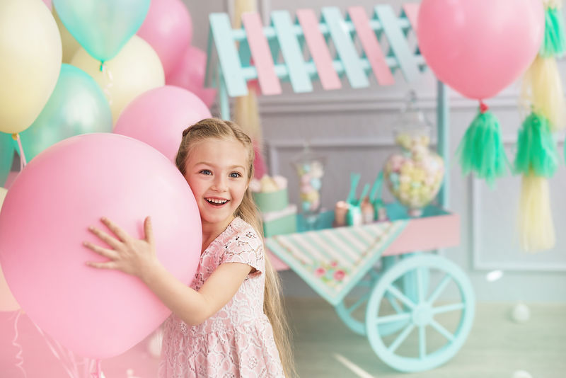 一个小女孩微笑着抱着一个大气球