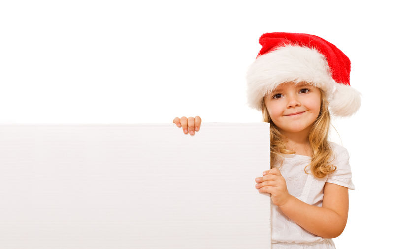 带着圣诞帽和白纸板的快乐小女孩