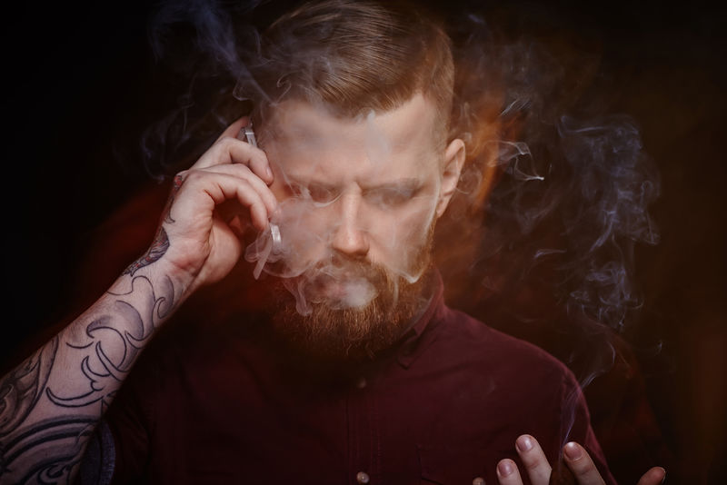 一个手臂上有纹身的人用智能手机说话