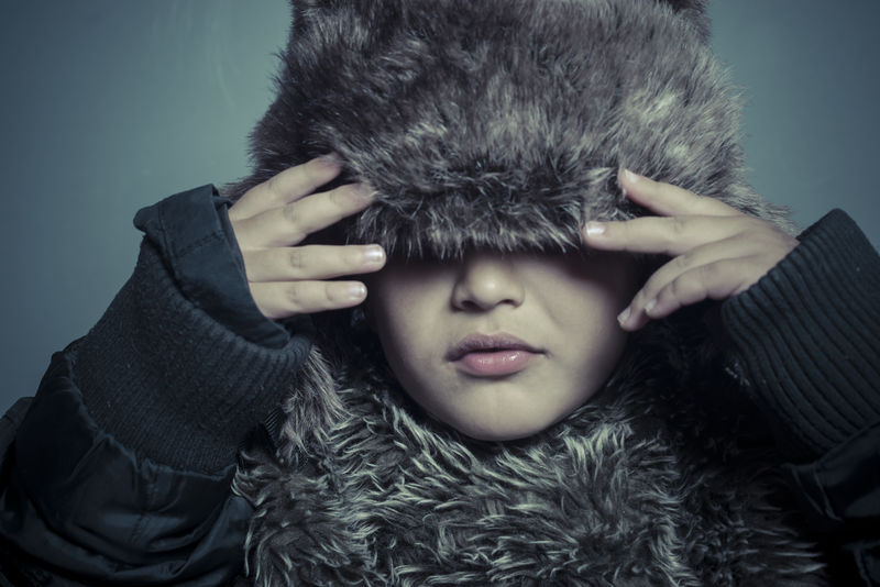 带皮帽和冬衣的幼儿寒冷的概念和暴风雨