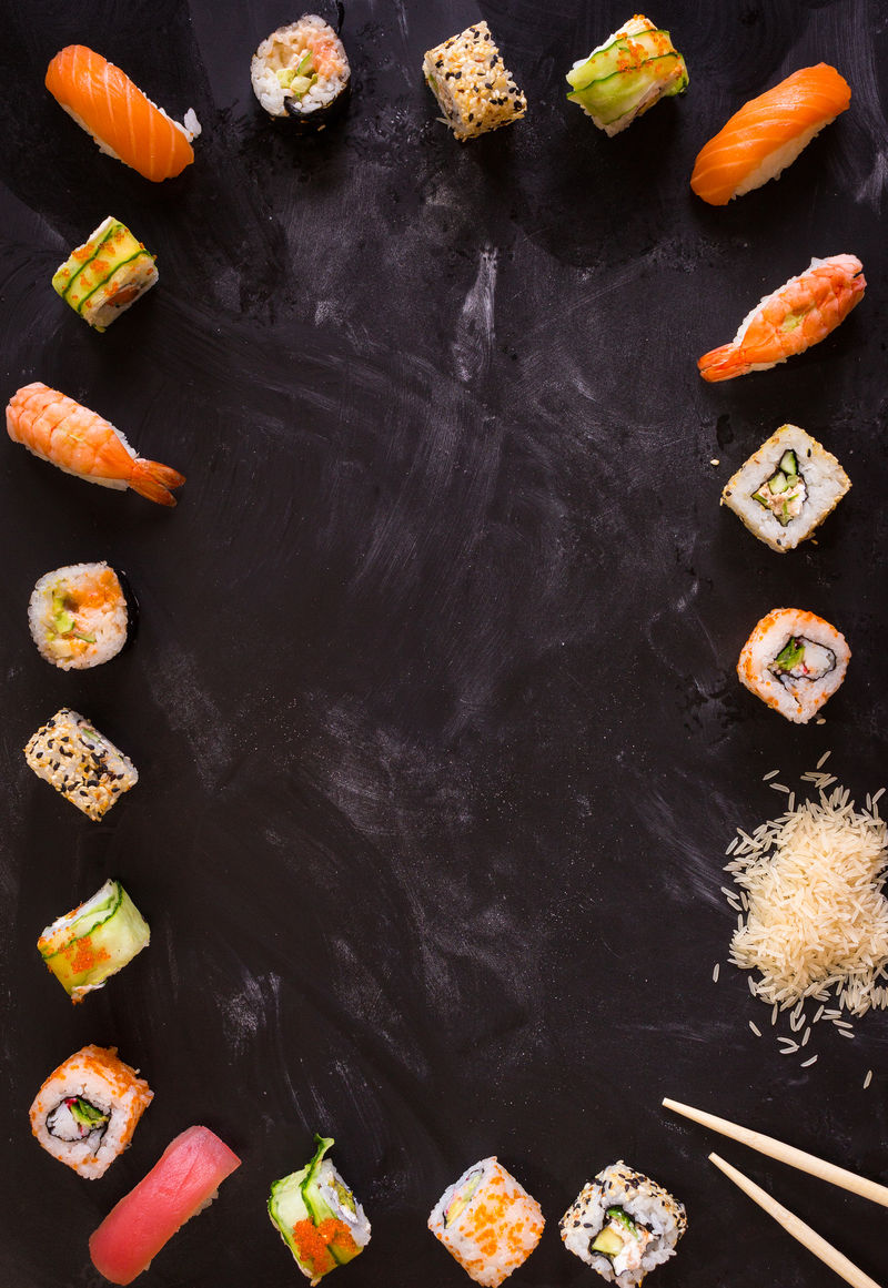 一套深色背景的日本传统食物寿司卷黑芝士生三文鱼排米饭奶油干酪鳄梨酸橙腌姜亚洲食品框架晚宴