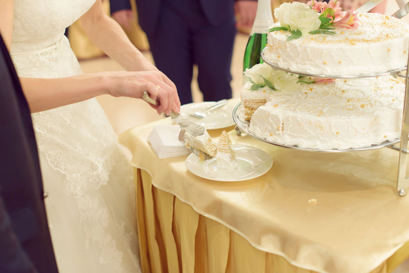 新娘把结婚蛋糕片放在盘子里