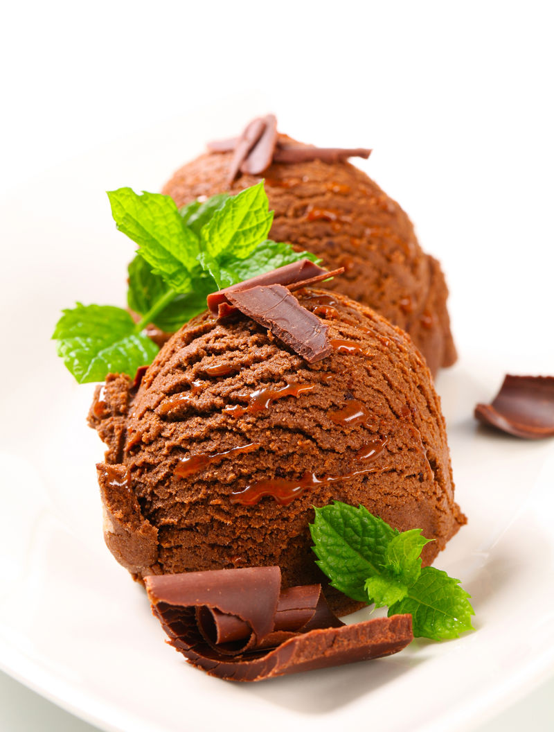 两勺用薄荷叶和巧克力卷装饰的巧克力冰淇淋