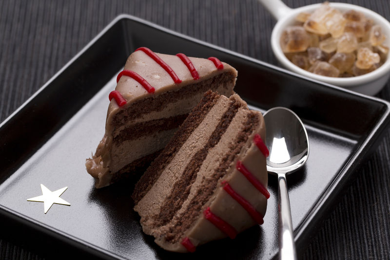 盘子上有红色装饰的巧克力蛋糕