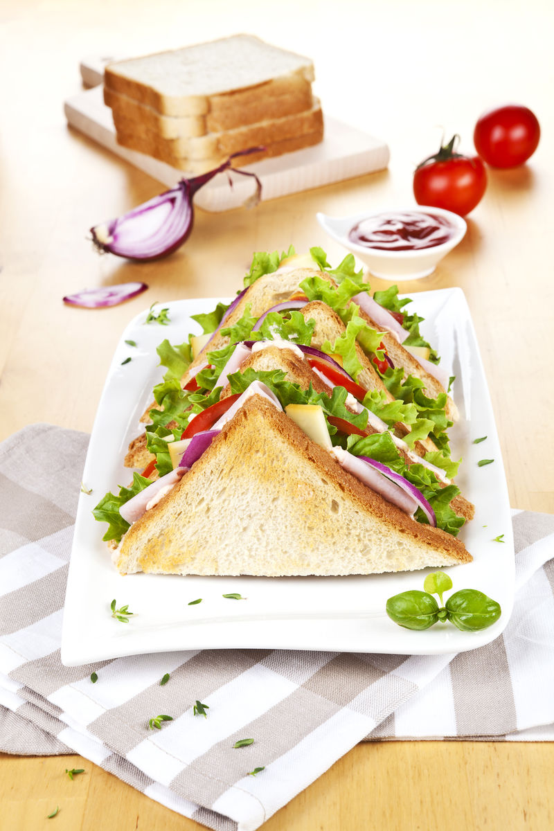 美味的三明治-新鲜蔬菜放在木桌上-配番茄洋葱香草和番茄酱