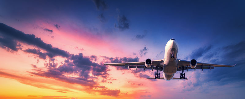 日落时-飞机在五彩缤纷的天空中降落-带着飞机的风景在蓝色天空中飞行-天空中有橙色和粉色的云-乘飞机旅行背景-商用飞机-私人飞机