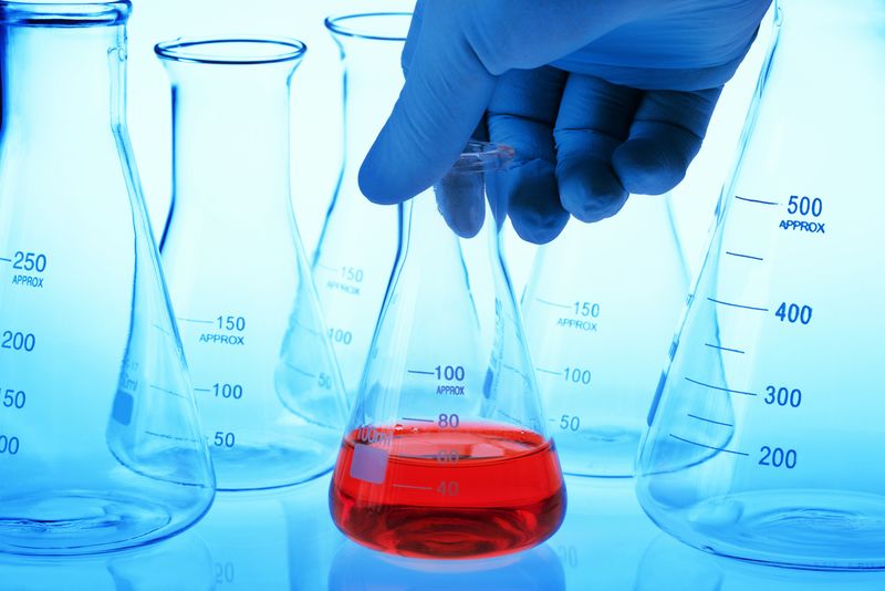 在实验室里-科学家手持装有红色液体的锥形烧瓶