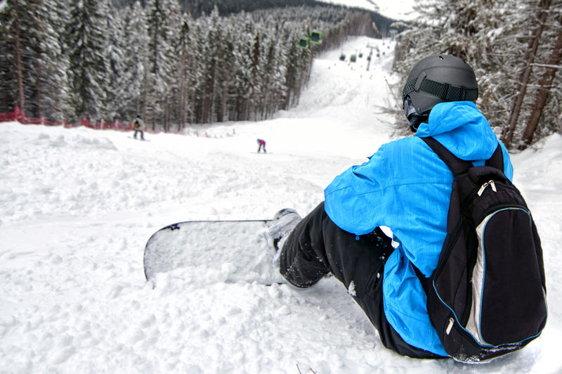 滑雪板运动员俯视困难斜坡的后视图