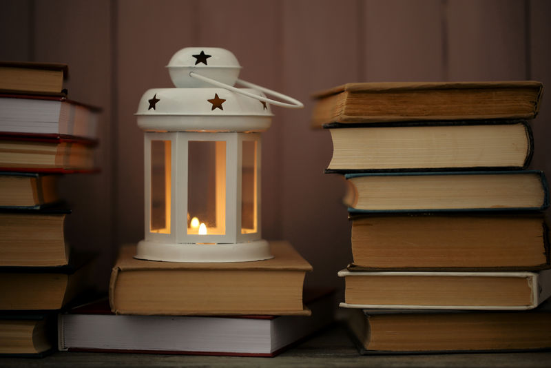 桌子和木板背景上的书籍和装饰灯