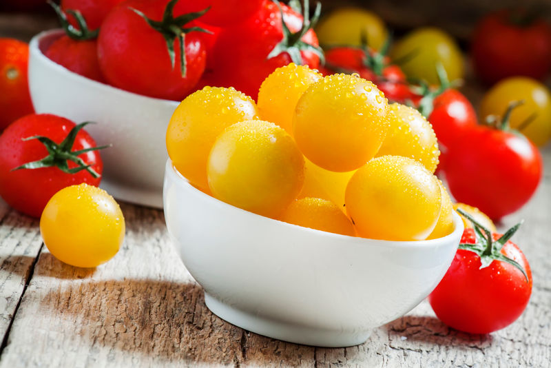 红色和黄色的樱桃番茄放在白色的瓷碗里