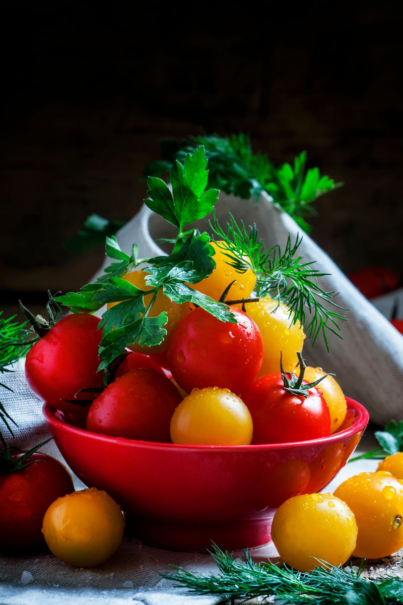 把红黄樱桃番茄欧芹和莳萝混合在红碗里