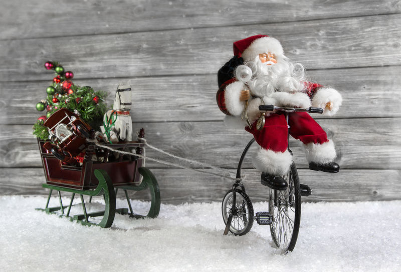 有趣的圣诞贺卡圣诞老人骑着自行车拉着一根绳子