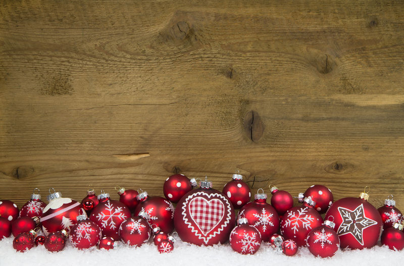 圣诞背景是用红球和雪装饰的木头
