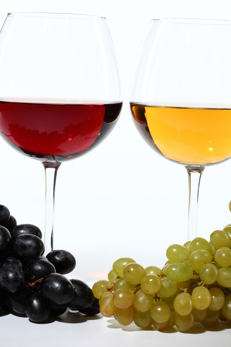 酒杯中的葡萄酒和白底的新鲜葡萄