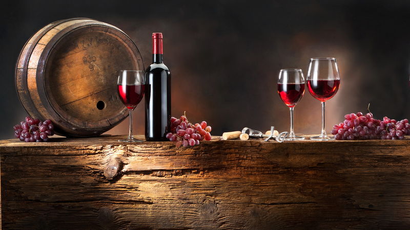 红葡萄酒瓶-两杯葡萄酒-木制桌上装饰着红心玫瑰-情人节庆祝概念-复制空间
