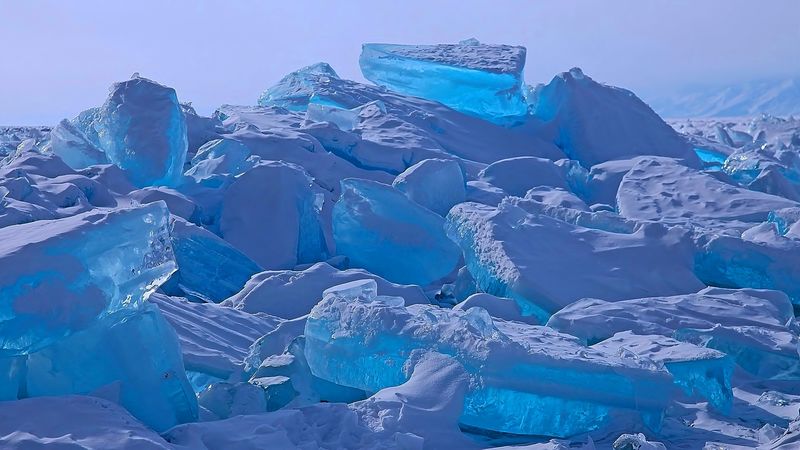 贝加尔湖上的奥尔孔岛北岸的冰丘-透明的透明冰块爬上岸-太阳光线的彩色折射-冰暴-照片部分着色
