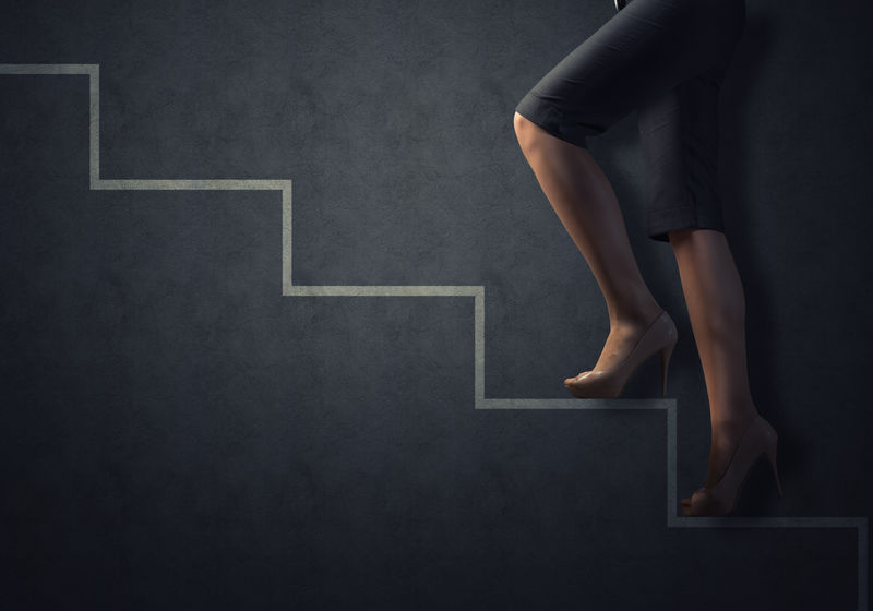 商业女性的双腿被拉上了楼梯-成功的商业理念