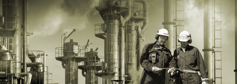 两名炼油厂工人-背景为工业厂房-乌云烟雾和烟雾