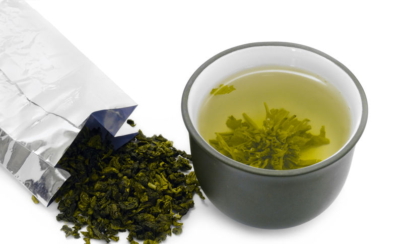 一杯绿茶和一包绿茶-传统的日本服务-热水中有健康的新鲜茶叶和禅宗式棕泥杯