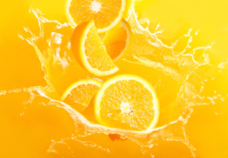 新鲜的橙子掉进果汁里-溅了很多的水花