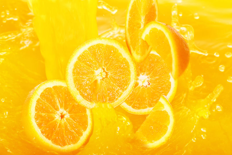 新鲜的橙子掉进果汁里-溅了很多的水花