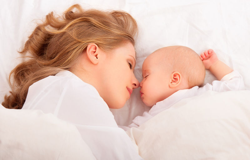 一起睡母亲把新生儿抱在床上