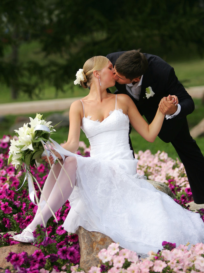 新婚夫妇在农村的花坛上接吻