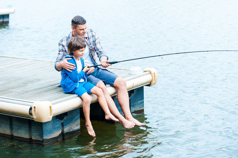 一起离开-爸爸和儿子在码头边钓鱼的俯视图