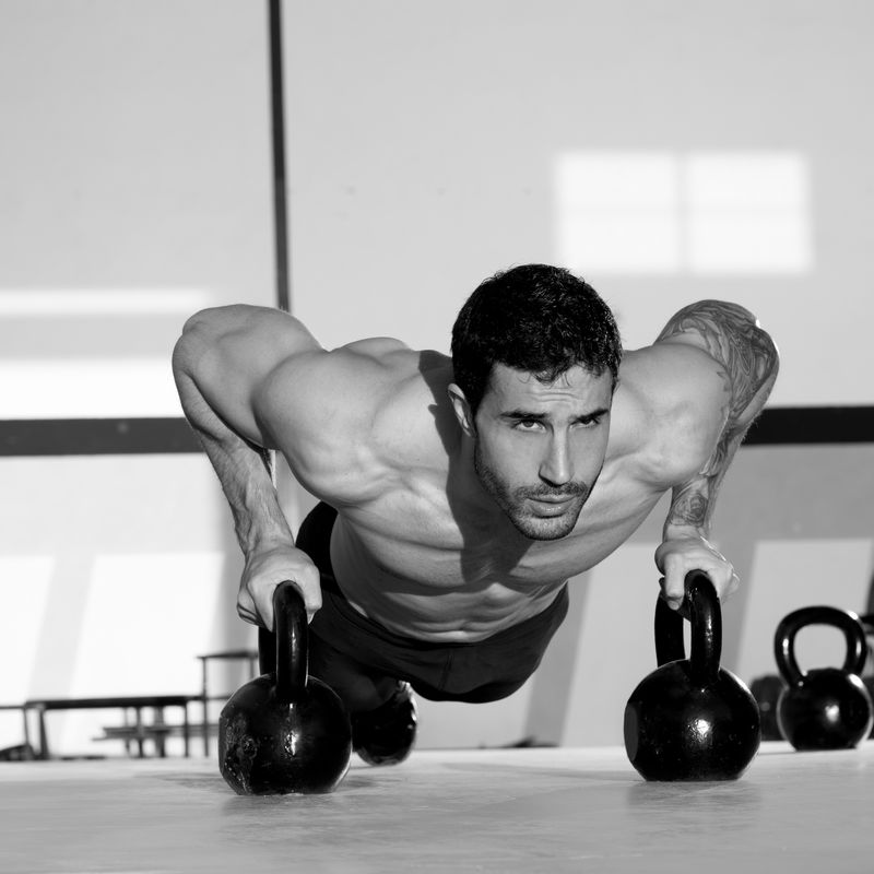 健身房的人推高强度俯卧撑和壶铃