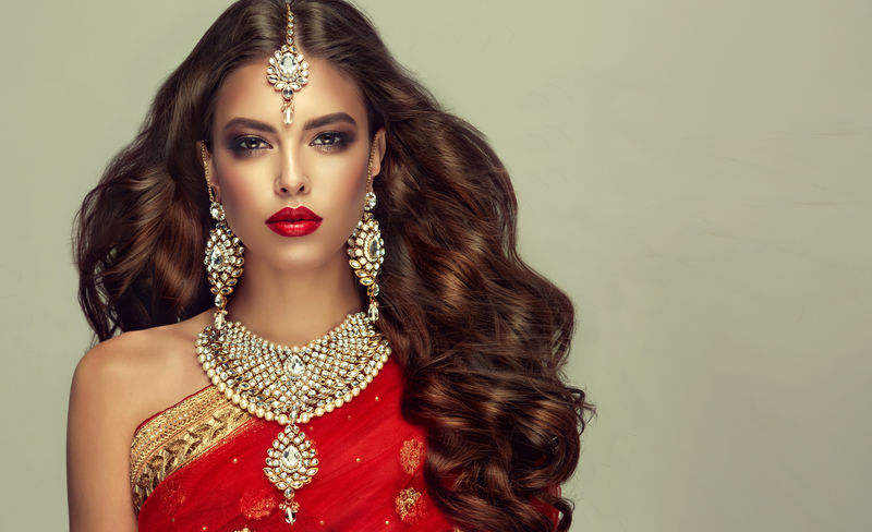 美丽的印度女孩的肖像年轻的印度教妇女模型与昆丹珠宝套装传统印度服装红色纱丽