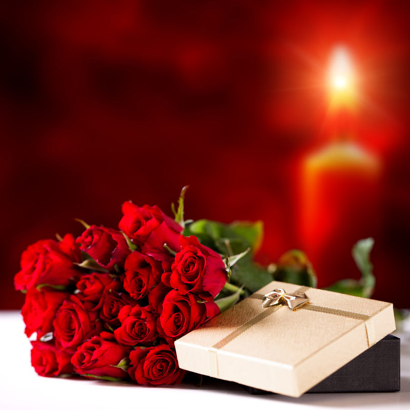 在烛光下的玫瑰和礼品盒