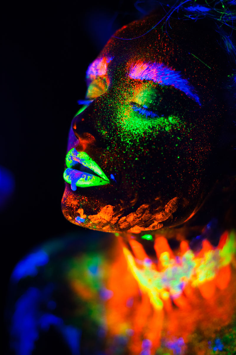 在霓虹灯下美丽的外星模特。这是一幅荧光彩妆的美丽模特的肖像画，是一幅女性在紫外光下摆姿势、彩妆的艺术设计。黑底隔离