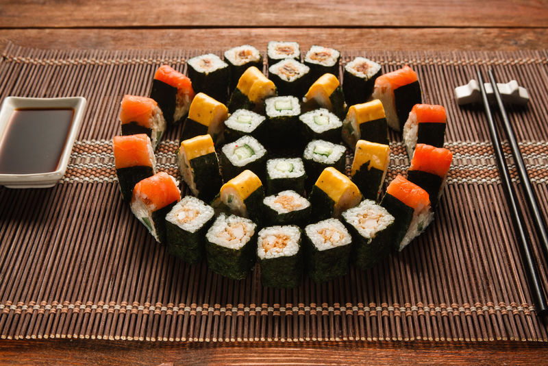 色彩鲜艳的日本寿司套装，棕色草席上的卷形装饰，特写。日本美食艺术，美食，餐厅菜单照片。