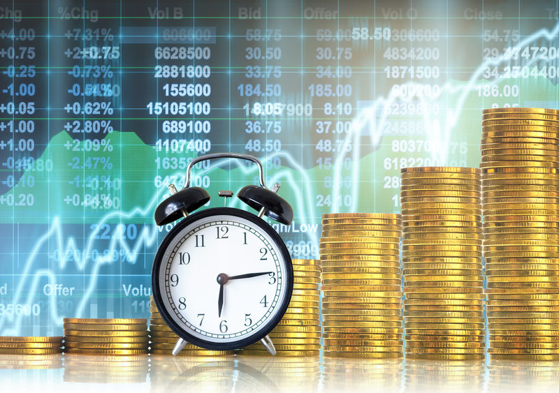 成堆的金币在LED显示屏上与老式时钟同步，显示股票市场交易数据背景、商业投资和交易理念。