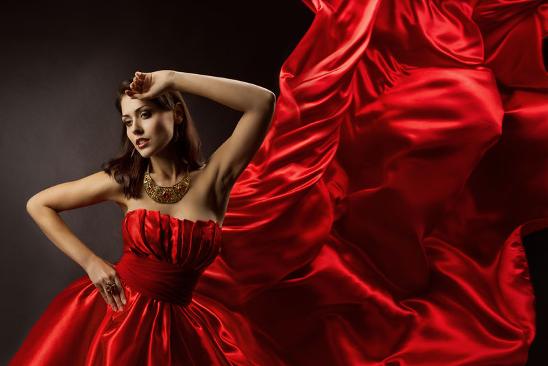 穿着红色连衣裙的女子用飞布跳舞