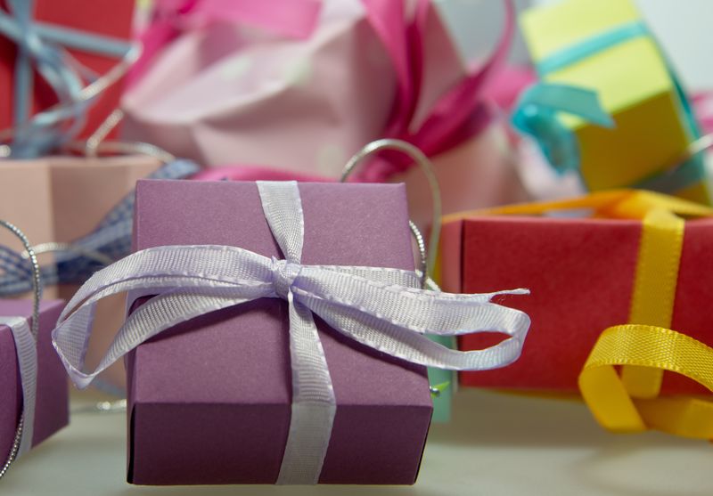 圣诞或其他庆祝活动的红色和粉色包装礼品-以及旧木质背景上的绿色槲寄生树枝