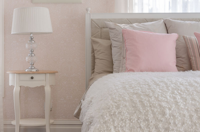 家里卧室白色豪华床上的粉红色枕头
