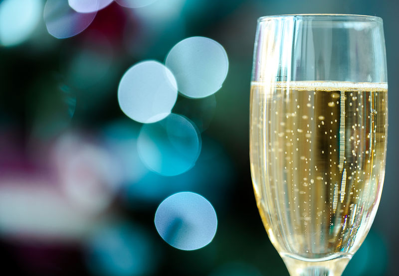 一杯香槟酒放在圣诞布基酒的背景上