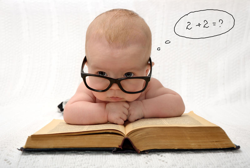 可爱的小婴儿的有趣画像-就像在浅色背景下读一本旧书一样