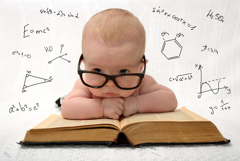 《戴着眼镜的可爱婴儿躺在旧书上的滑稽画像》-思考着世界上所有的知识