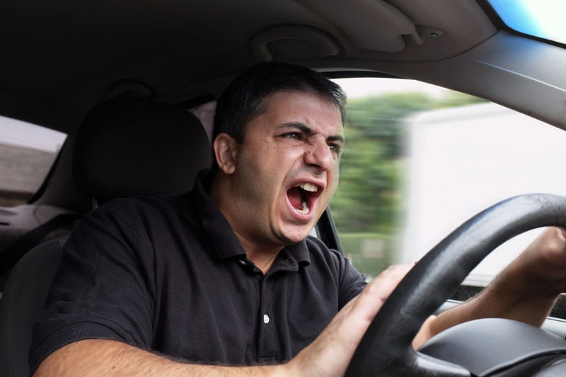 愤怒的男人驾驶没有系安全带的车辆