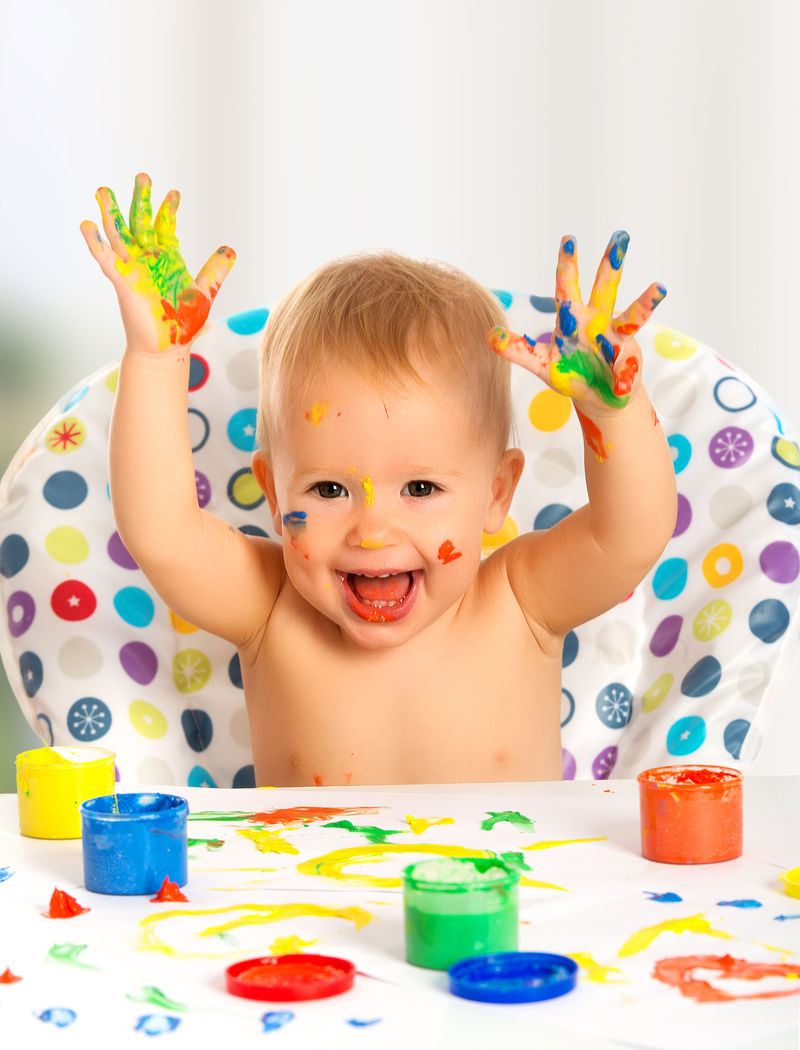 快乐的幼儿用彩绘的手画画